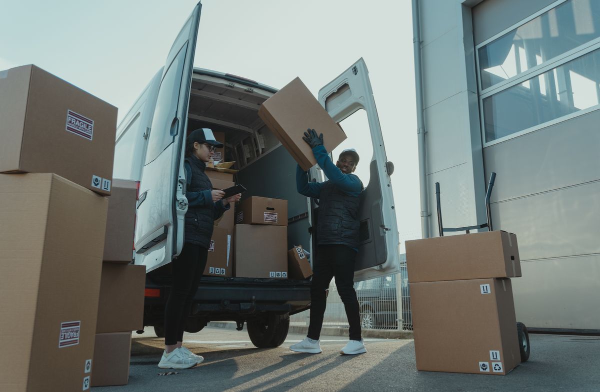 Chargement de colis de gilets de sécurité personnalisés dans une camionnette de transport